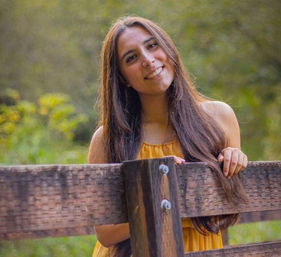 ひげを生やした男性が茶色のTシャツとネックレスを着用