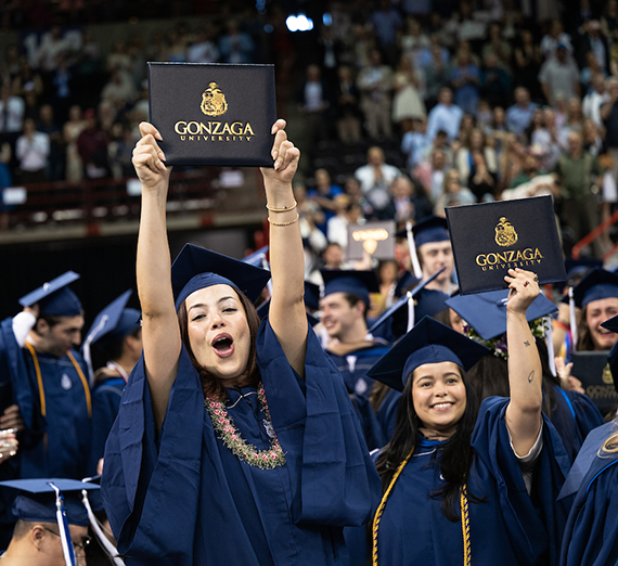 男性がレンガの壁に寄りかかり、背後には桜の木が広がる